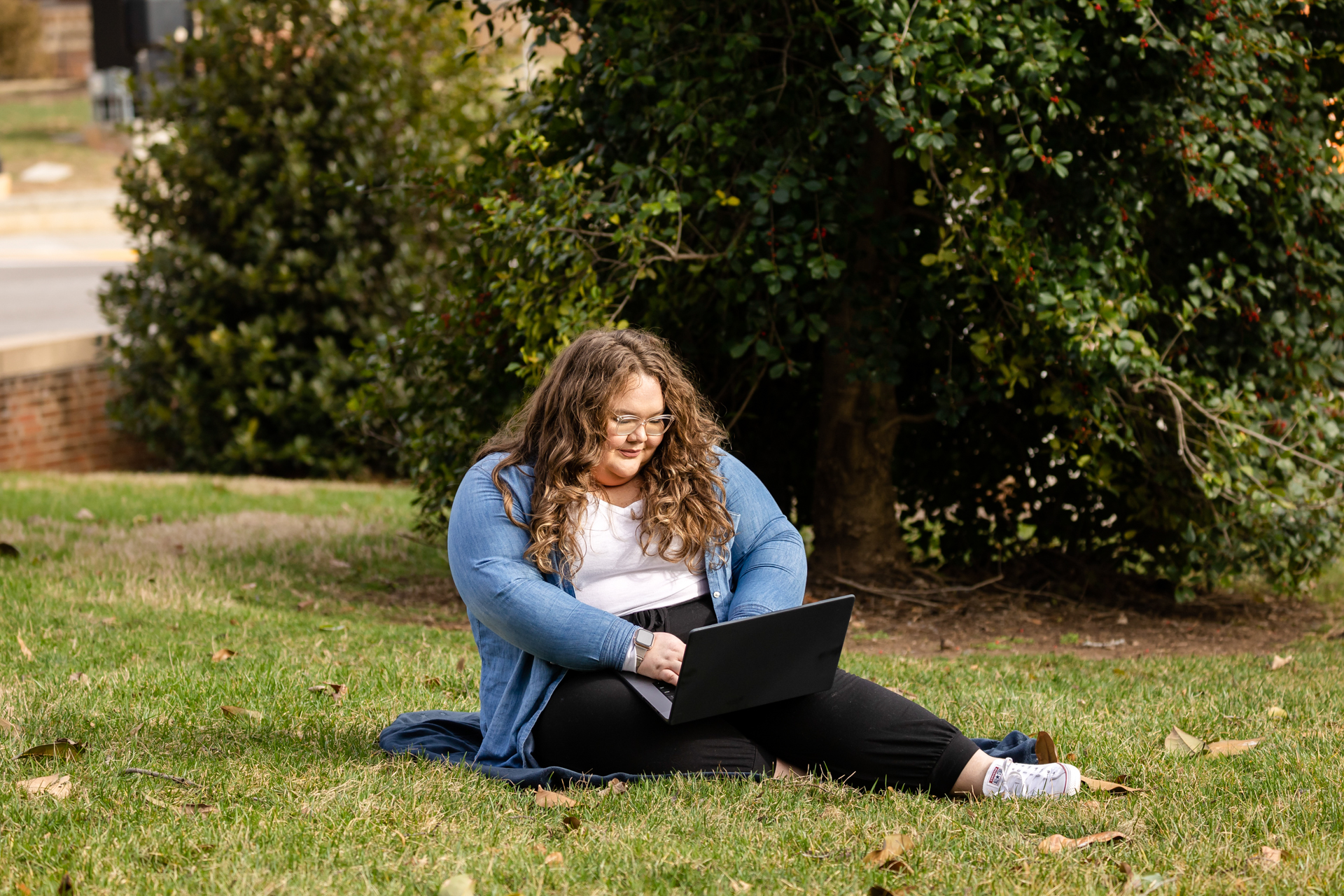 social work student working on her laptop in the grass
