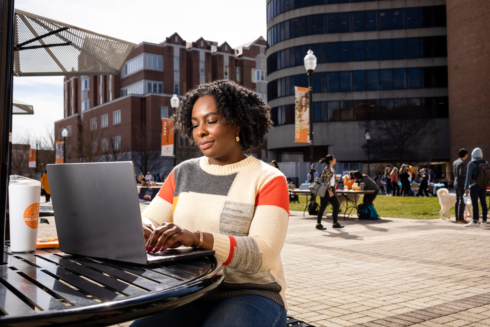 MSSW student working on laptop outside of Student Union on University of tennessee campus