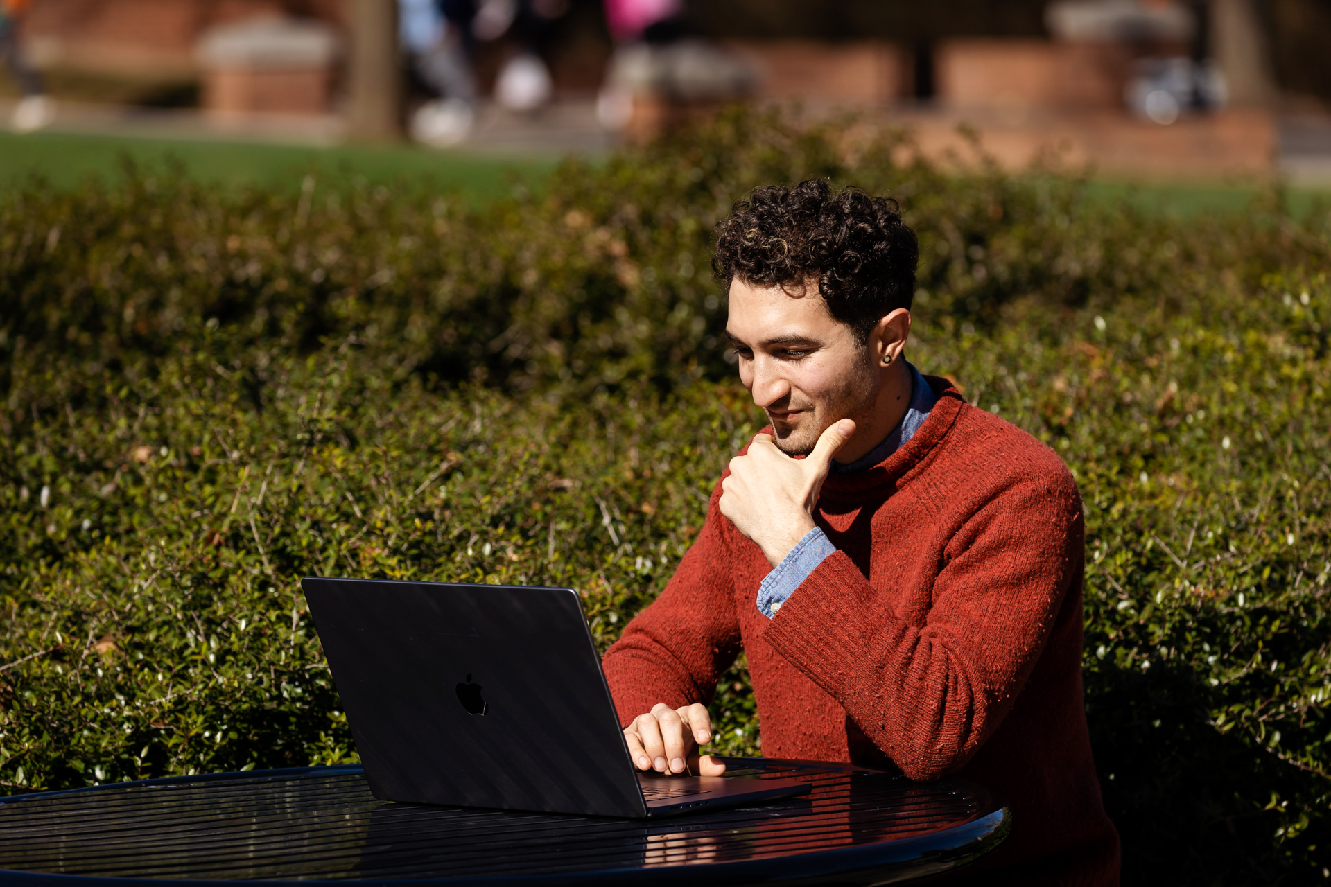Online social work student working outside on a sunny day