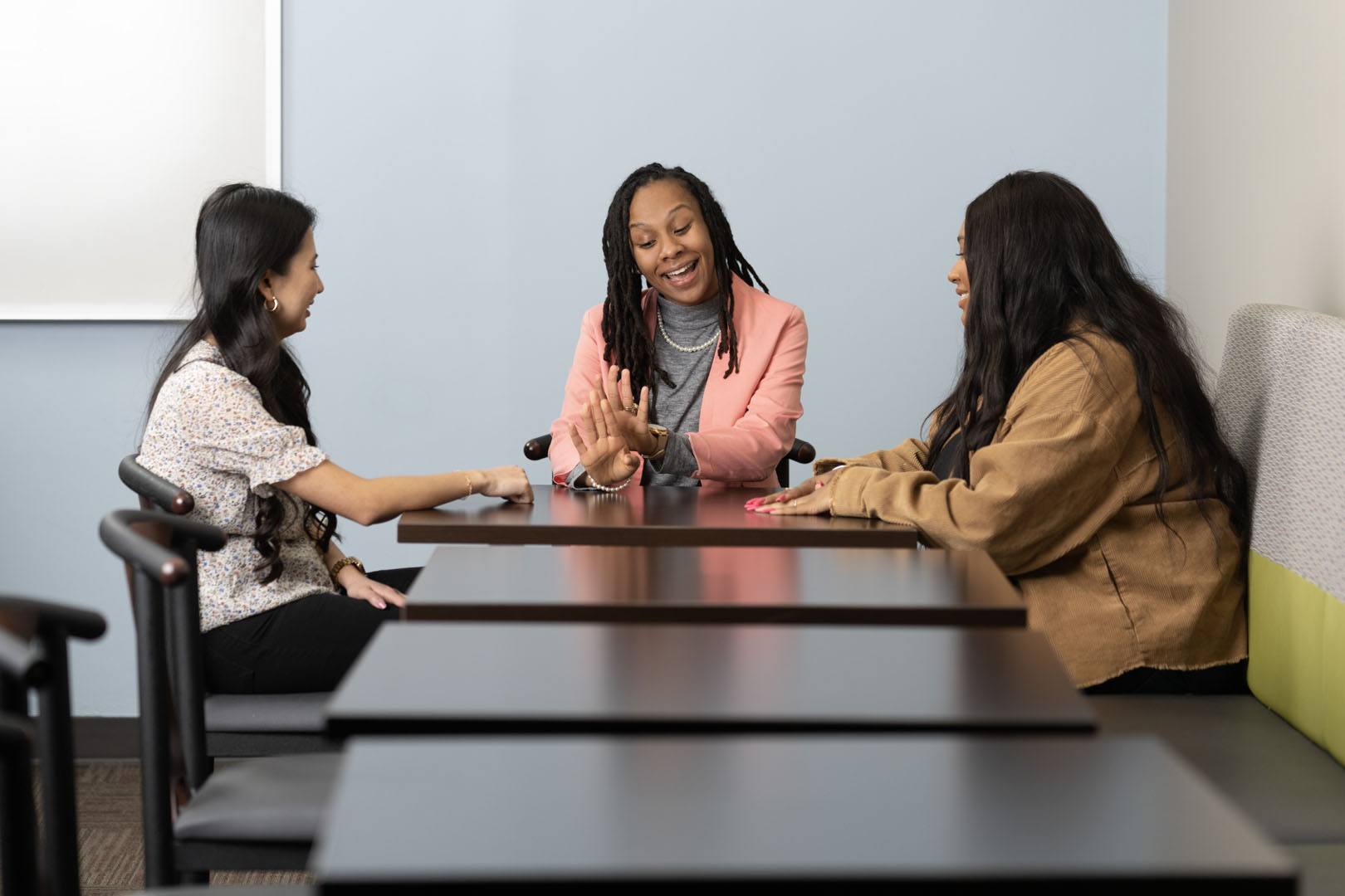 three female social work students sitting at a table talking