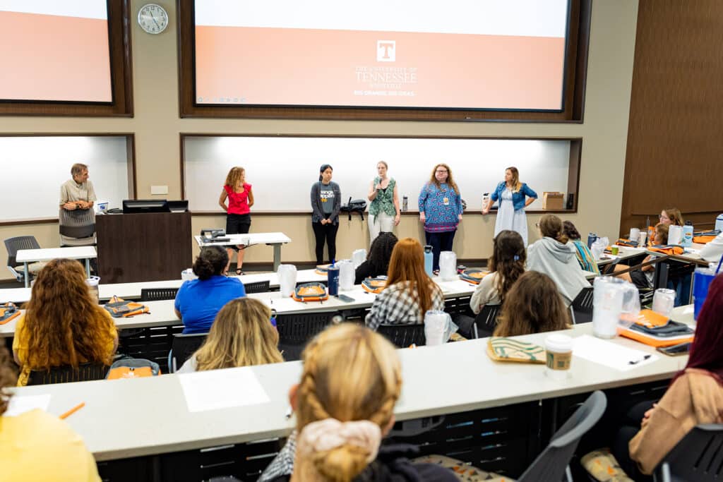 college of social work faculty and staff speaking to students in auditorium 