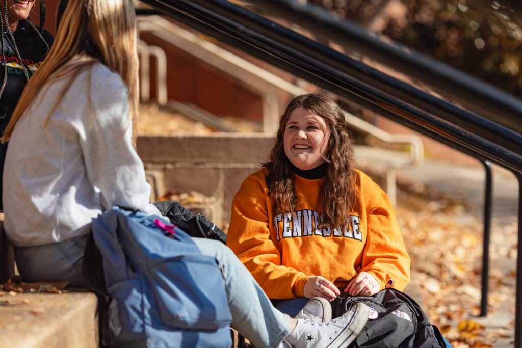 bssw student sitting on steps with a friend on UT campus during fall