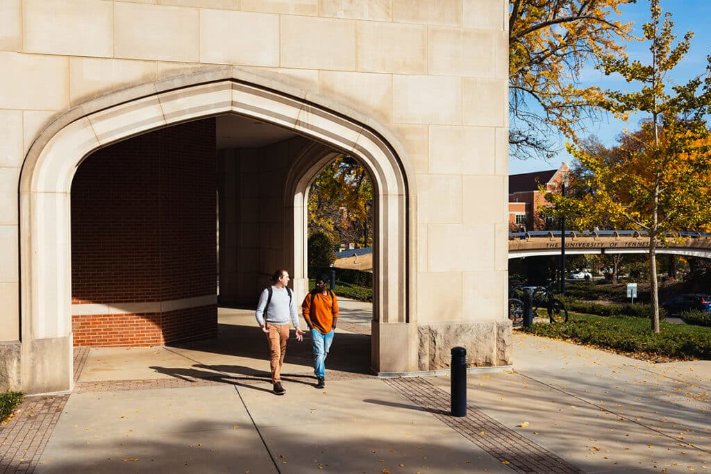 two phd students walking on a sidewalk outside of Strong Hall