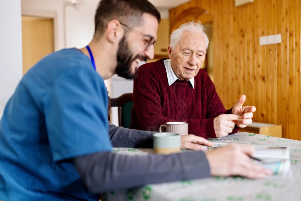 Caretaker with senior man enjoying coffee break