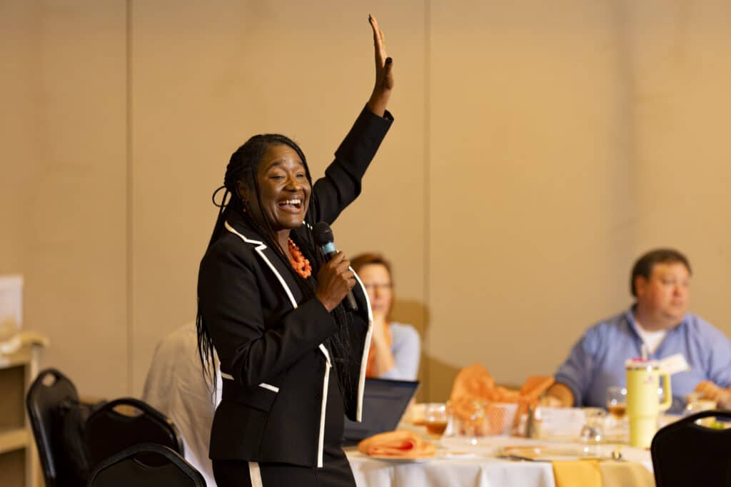 Javonda Williams-Moss speaking into microphone at college retreat