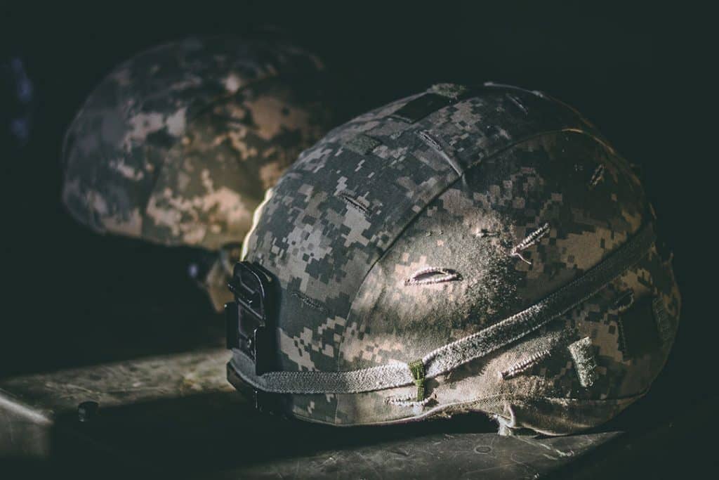 two military helmets sitting on table