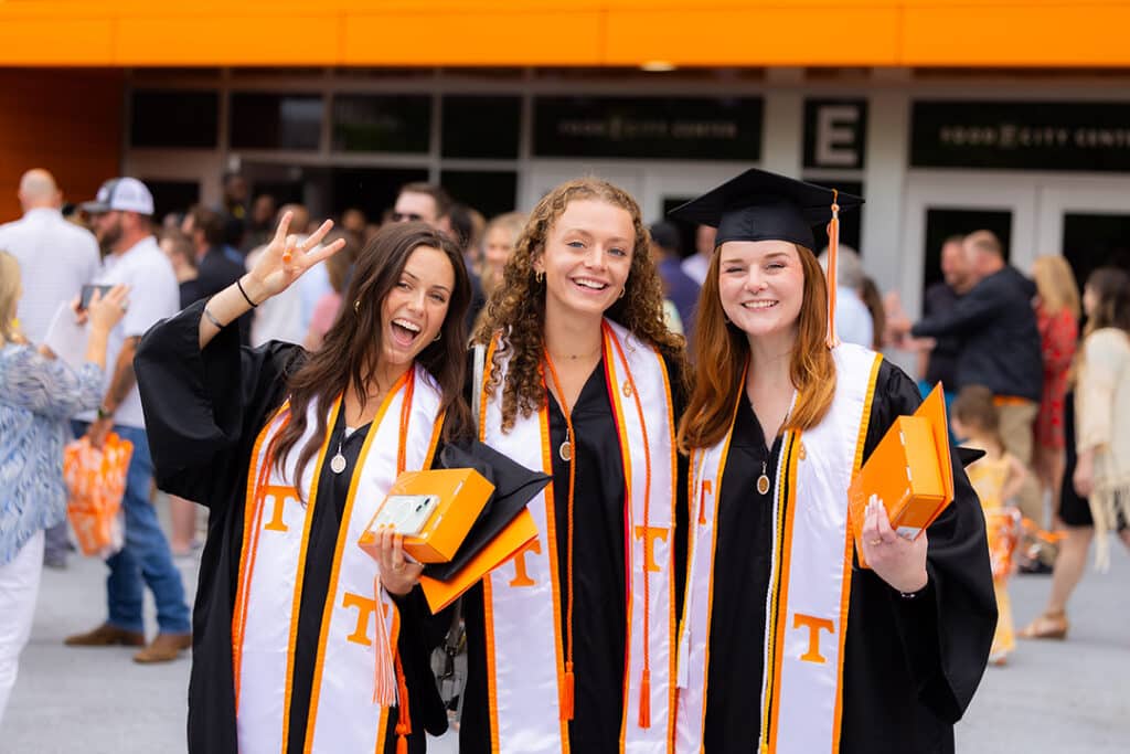 Graduates pose for a group photo after the College of Social Work commencement ceremony outside Thompson-Boling Arena at Food City Center