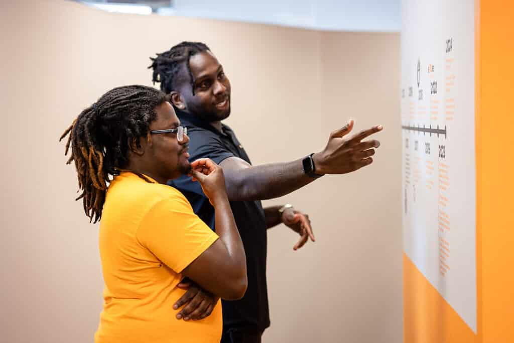 Johnson Decembre showing Jason Davis the CSW timeline in Stokely management center