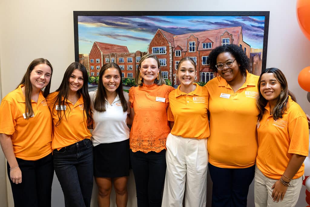 college of social work student ambassadors and Macy Etter posing with portrait of Henson Hall