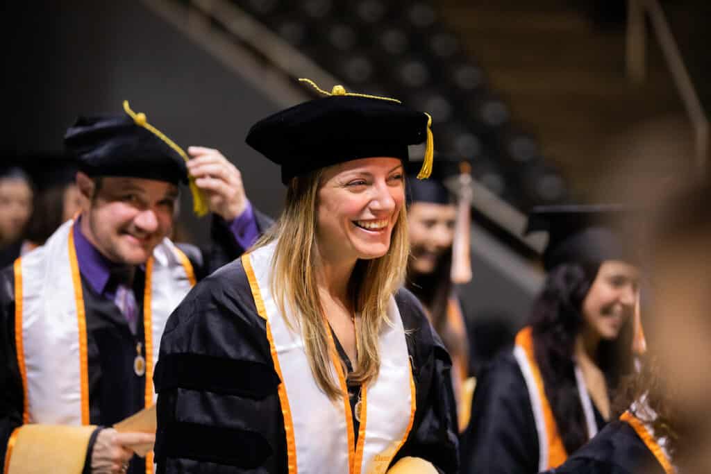 social work doctorate graduates smiling in their regalia 