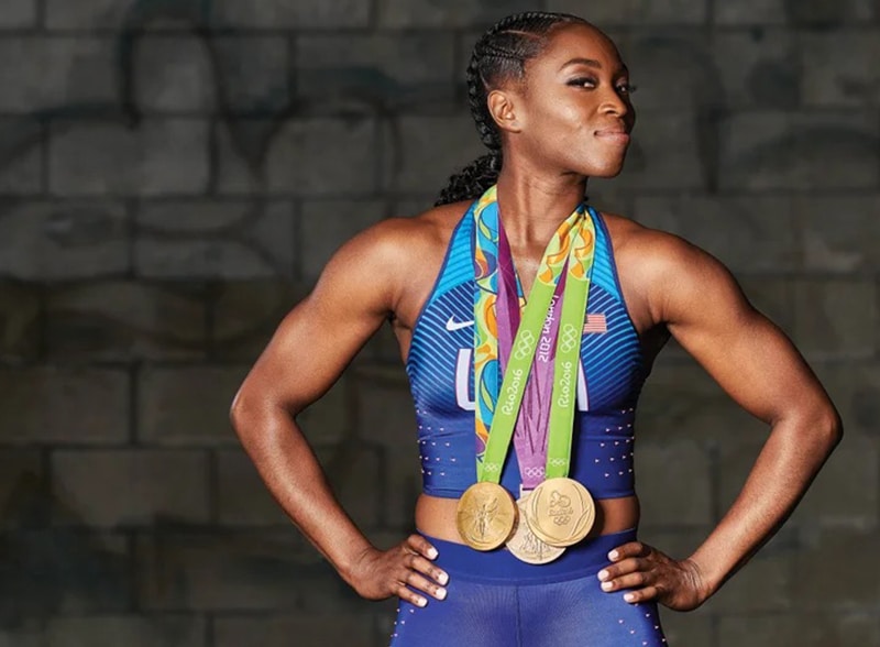 tianna madison wearing gold medals and track uniform