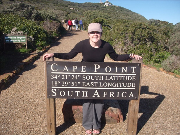 social work study abroad student standing with cape town south africa sign