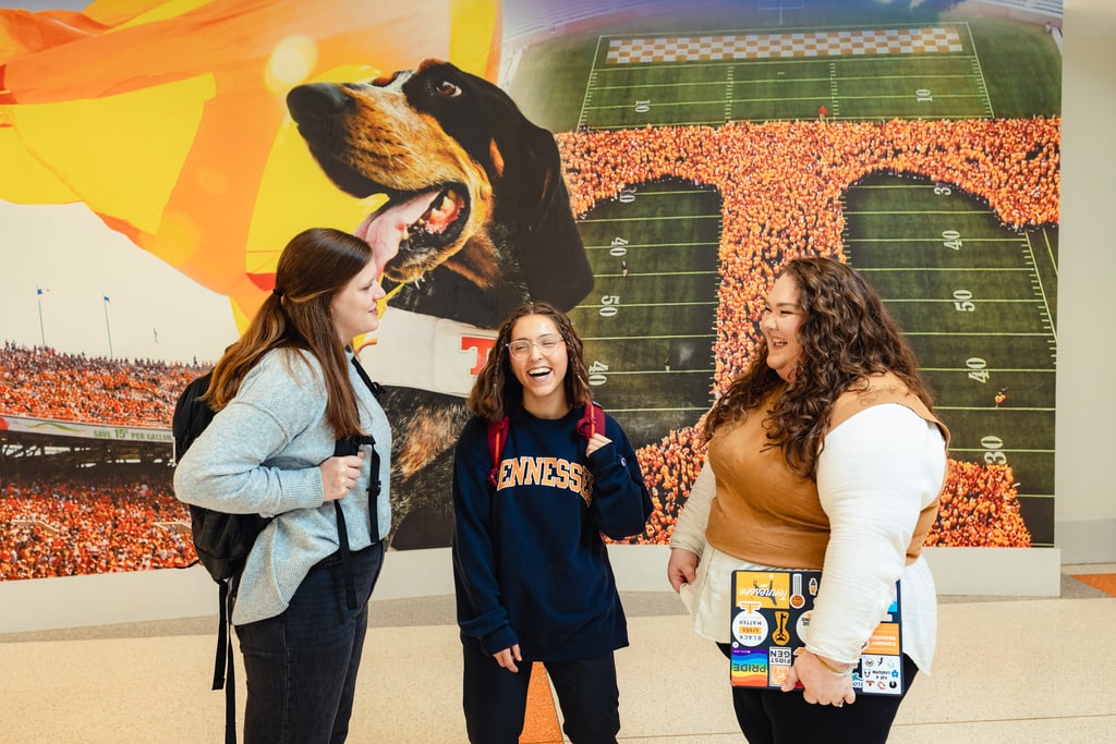 three social work BSSW students hanging out in UTK student union hallway infront of a UTK mural