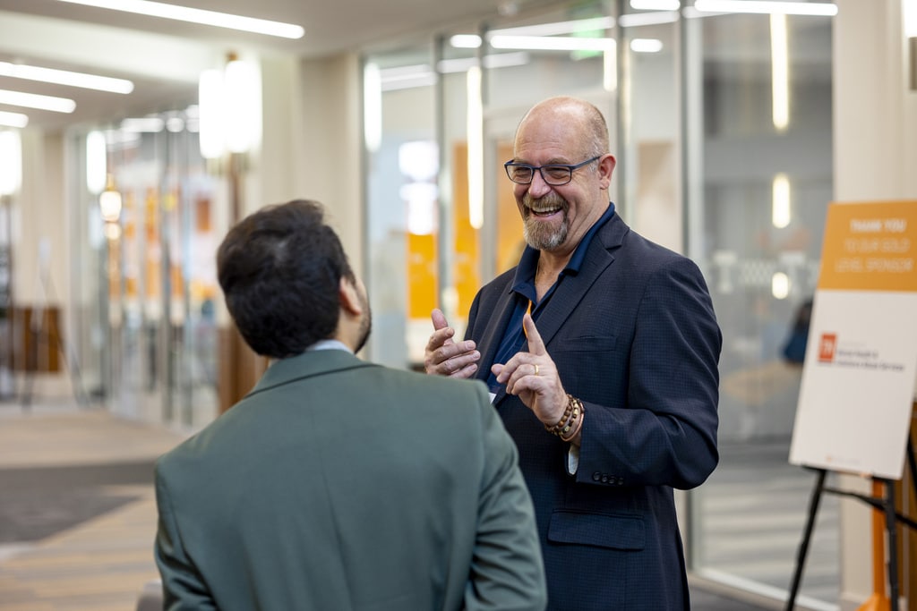 Dr. Douglass Coatsworth smiling and talking to a social work PhD student 