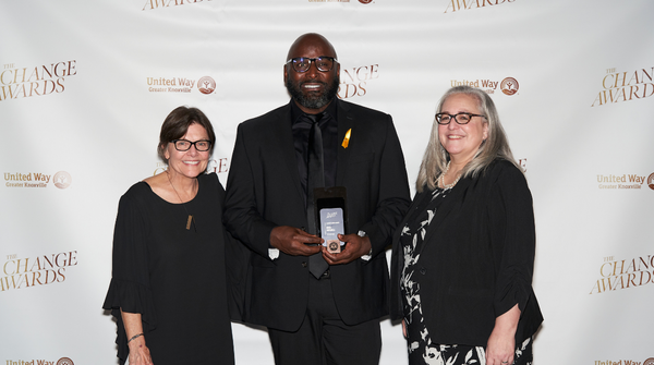 two women and one man facing the camera, man holding United Way Change Leader Award